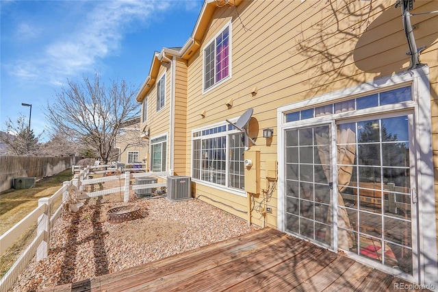 wooden terrace with a fenced backyard and central AC unit