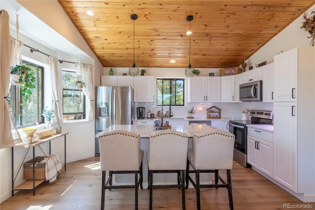 51 Schooley Rd, Bailey, CO 80421 - kitchen with appliances with stainless steel finishes, vaulted ceiling, wood ceiling, white cabinets, and a center island