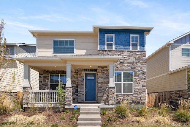 868 N Quatar St, Aurora, CO 80018 - view of front of property featuring stone siding, a porch, and fence