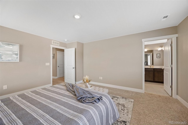 bedroom featuring light carpet, baseboards, and connected bathroom