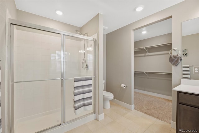 bathroom featuring a shower stall, toilet, vanity, a walk in closet, and recessed lighting