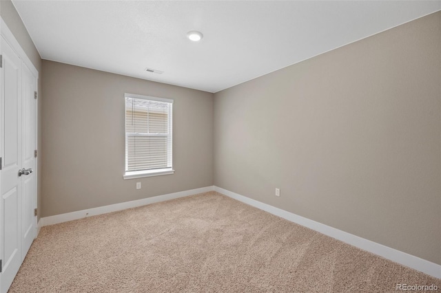 carpeted spare room featuring baseboards