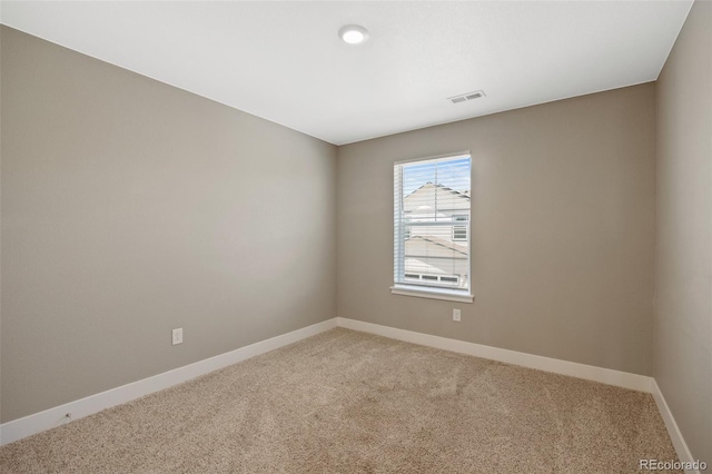 spare room with light carpet and baseboards