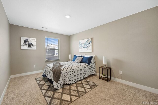bedroom featuring light carpet and baseboards