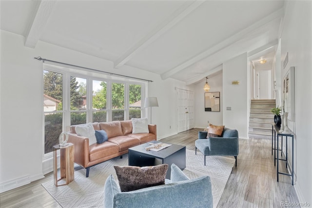 living area with stairs, light wood-type flooring, and baseboards