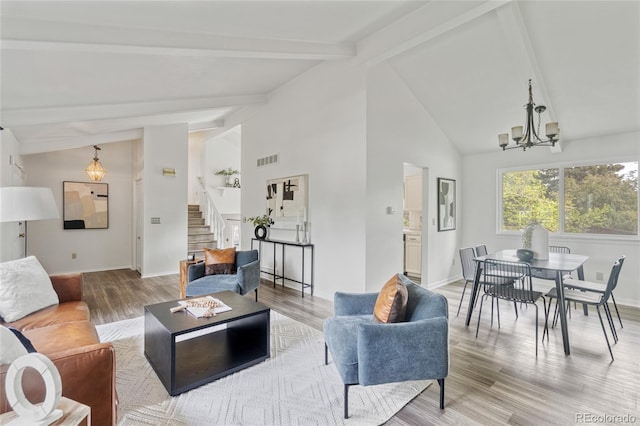 living area featuring stairway, a chandelier, light wood-style flooring, beamed ceiling, and high vaulted ceiling