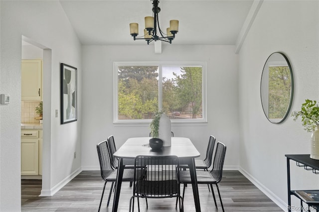 dining area featuring a chandelier, wood finished floors, and baseboards