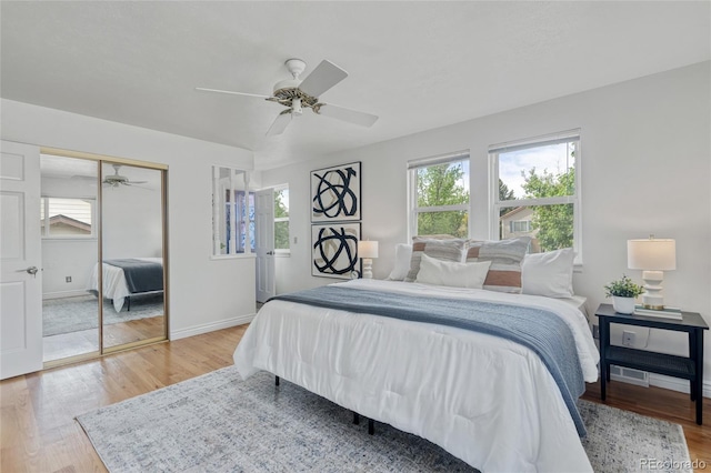 bedroom with light wood-style flooring, a closet, baseboards, and a ceiling fan