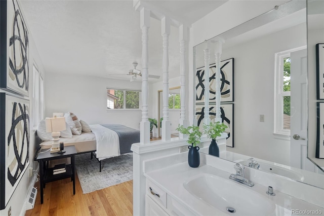 bathroom with a ceiling fan, wood finished floors, and vanity