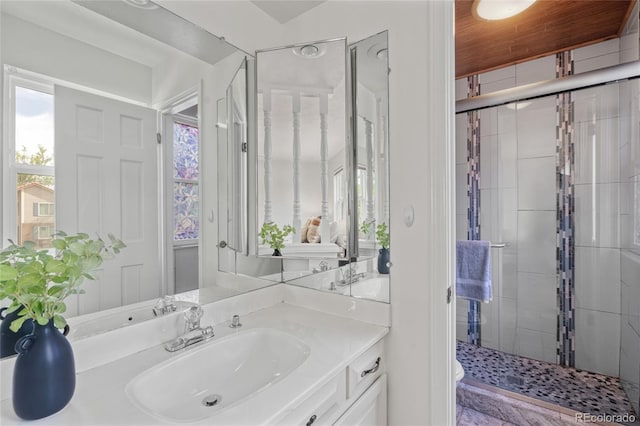 bathroom with a stall shower, vanity, and toilet