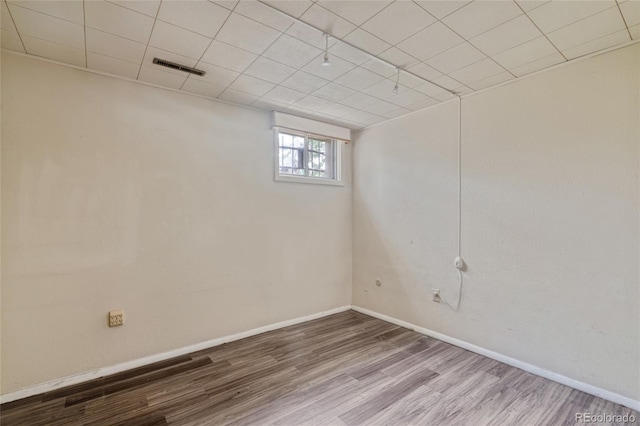 basement featuring wood finished floors and baseboards