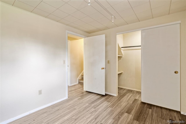 unfurnished bedroom with wood finished floors, a closet, and baseboards
