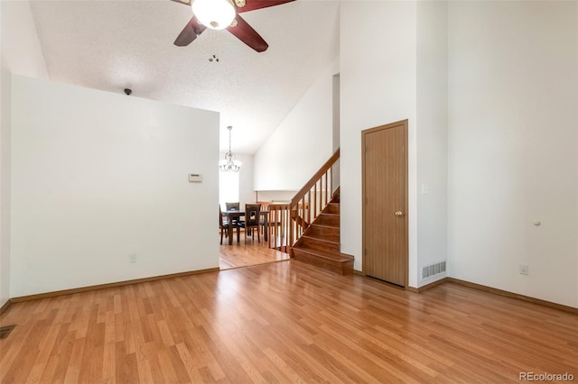 7732 Xavier Ct, Westminster, CO 80030 - empty room with stairs, a chandelier, light wood-type flooring, a ceiling fan, and high vaulted ceiling