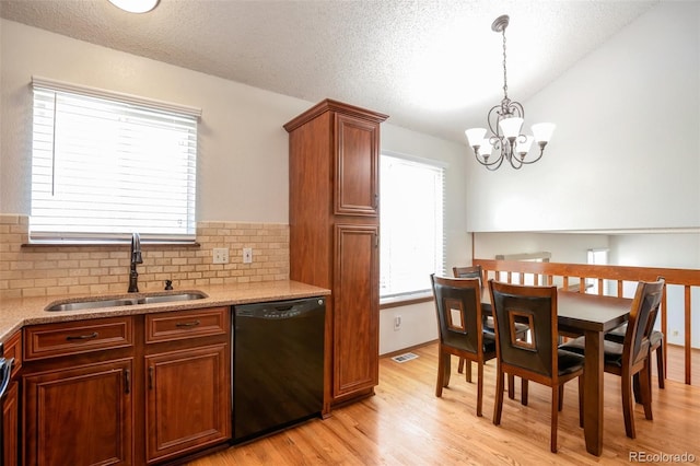 7732 Xavier Ct, Westminster, CO 80030 - kitchen featuring dishwasher, a sink, vaulted ceiling, light wood-style flooring, and a chandelier