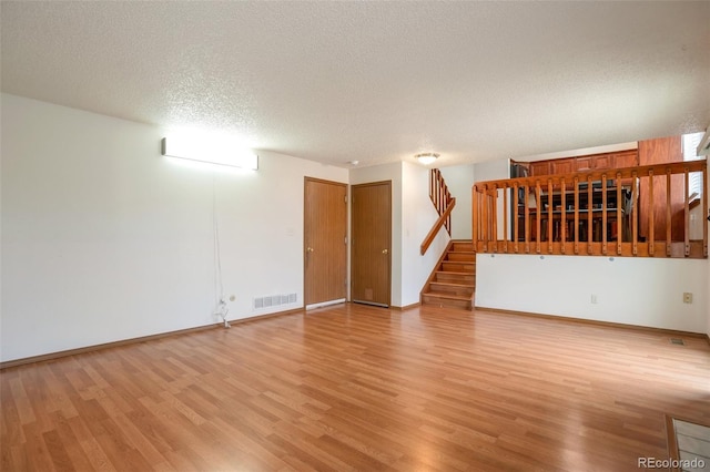 7732 Xavier Ct, Westminster, CO 80030 - empty room with a textured ceiling, light wood-type flooring, stairway, and baseboards