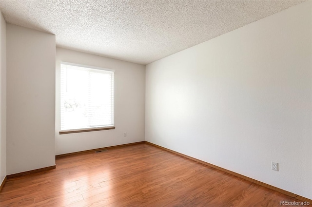 7732 Xavier Ct, Westminster, CO 80030 - empty room with light wood-style floors, baseboards, and a textured ceiling