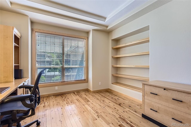 office area featuring light wood-type flooring, built in features, and baseboards