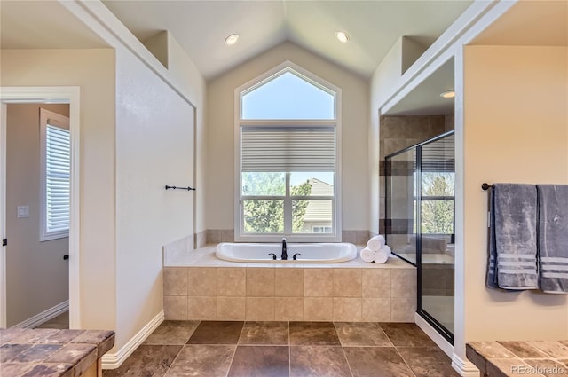 full bathroom featuring a shower stall, a garden tub, and vaulted ceiling
