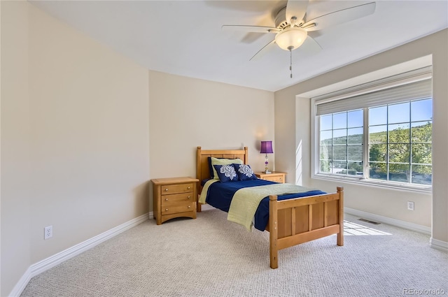 bedroom featuring light carpet, baseboards, and ceiling fan