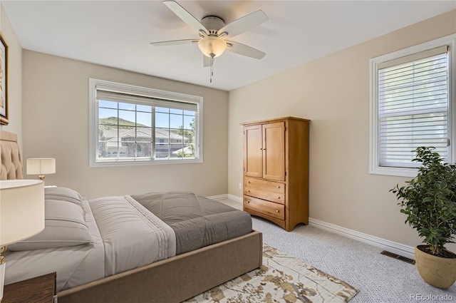 bedroom featuring baseboards, light colored carpet, and ceiling fan