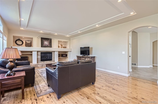 10529 Dacre Pl, Lone Tree, CO 80124 - living room with a tray ceiling, arched walkways, recessed lighting, light wood-style floors, and built in features