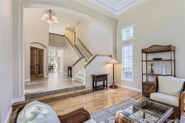 10529 Dacre Pl, Lone Tree, CO 80124 - living area with healthy amount of natural light, arched walkways, a high ceiling, stairway, and a chandelier