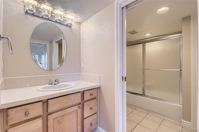 10529 Dacre Pl, Lone Tree, CO 80124 - bathroom with a textured wall, vanity, shower / bath combination with glass door, and tile patterned flooring