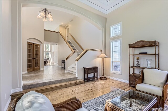 10529 Dacre Pl, Lone Tree, CO 80124 - living area with healthy amount of natural light, arched walkways, a high ceiling, stairway, and a chandelier