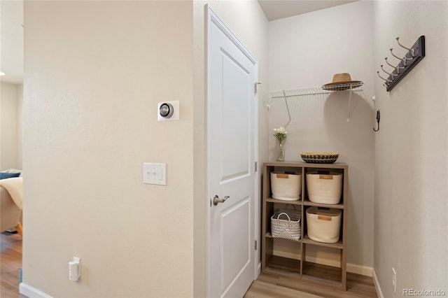 corridor with light wood-style flooring and baseboards
