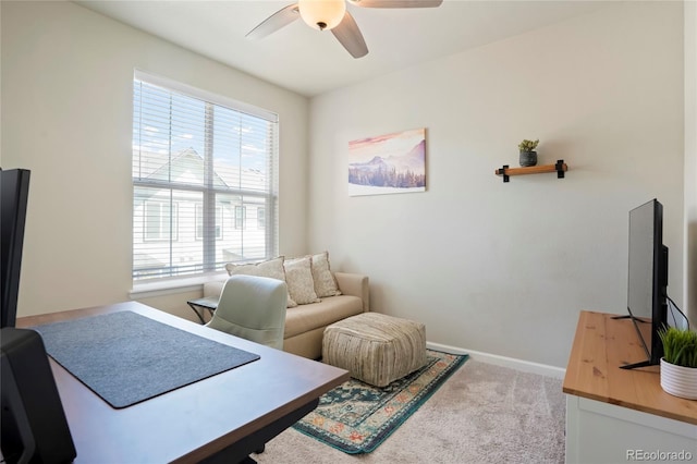 carpeted office space with a ceiling fan, a wealth of natural light, and baseboards