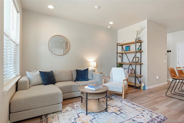 living area with baseboards, recessed lighting, and light wood-type flooring