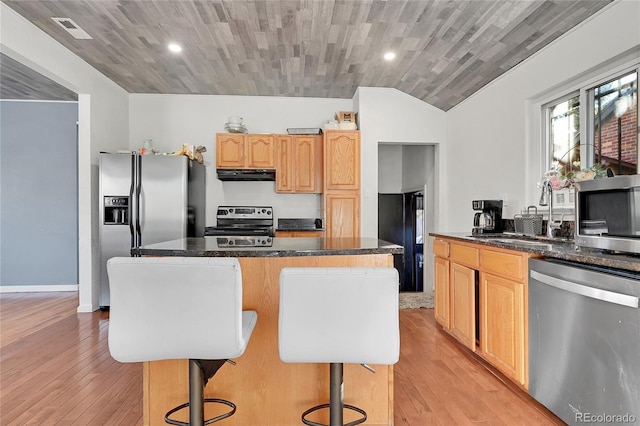 kitchen featuring appliances with stainless steel finishes, a center island, sink, and a kitchen breakfast bar