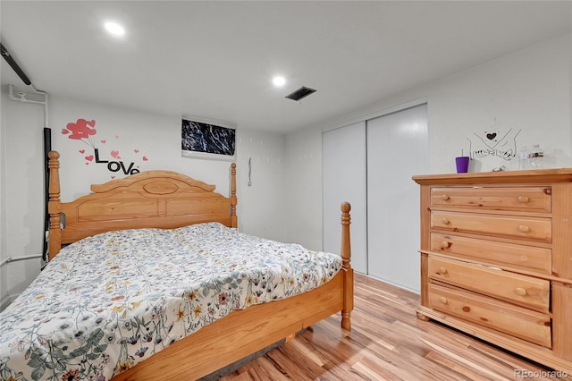 bedroom with light hardwood / wood-style flooring and a closet