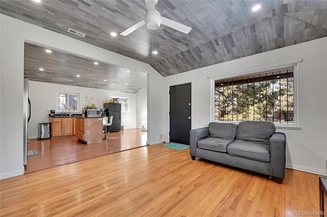 living room featuring vaulted ceiling, ceiling fan, and light wood-type flooring