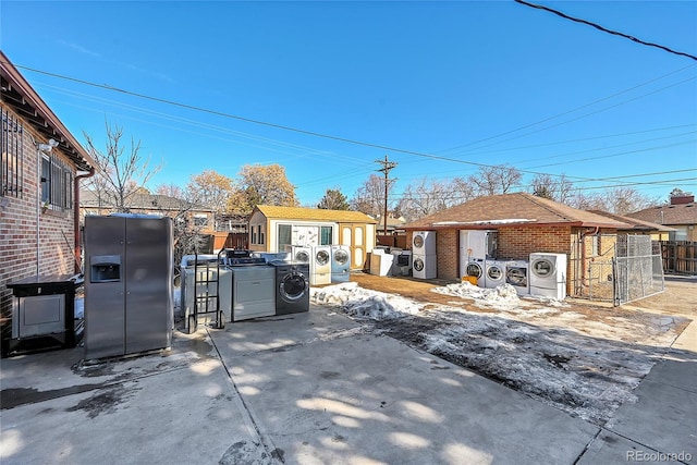 exterior space featuring washer / dryer and a storage unit