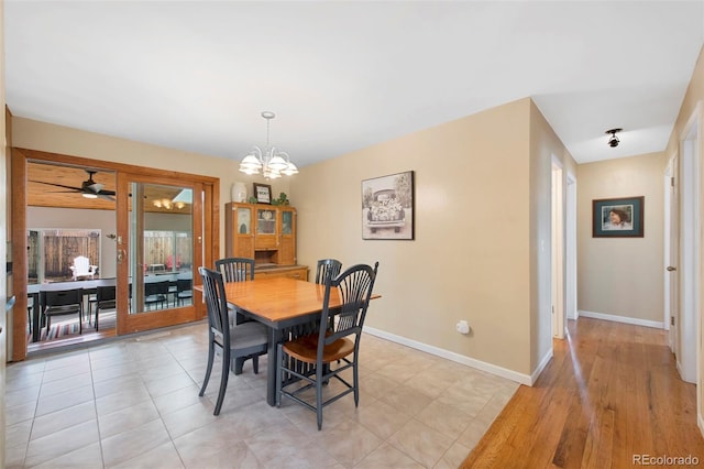 dining space with light tile patterned floors, baseboards, and a chandelier