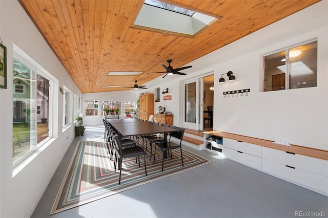 dining room featuring wooden ceiling, finished concrete flooring, a wealth of natural light, and lofted ceiling with skylight