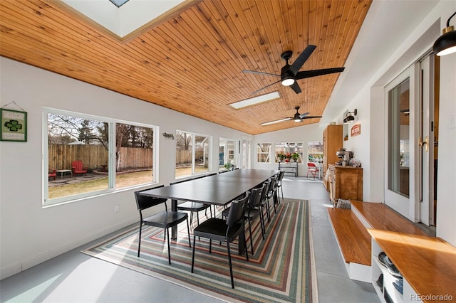 dining area with wood ceiling, lofted ceiling with skylight, a healthy amount of sunlight, and finished concrete floors