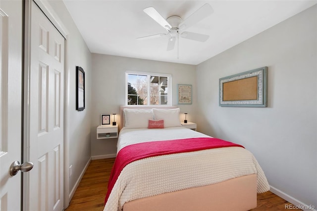 bedroom featuring a ceiling fan, baseboards, and wood finished floors