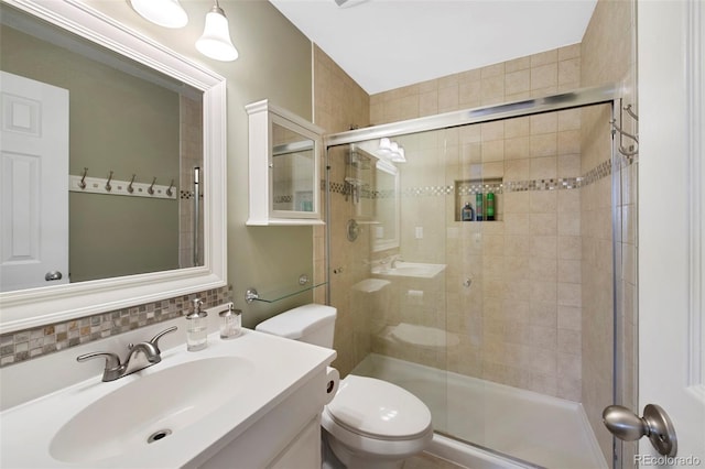 full bathroom featuring vanity, toilet, and a shower stall