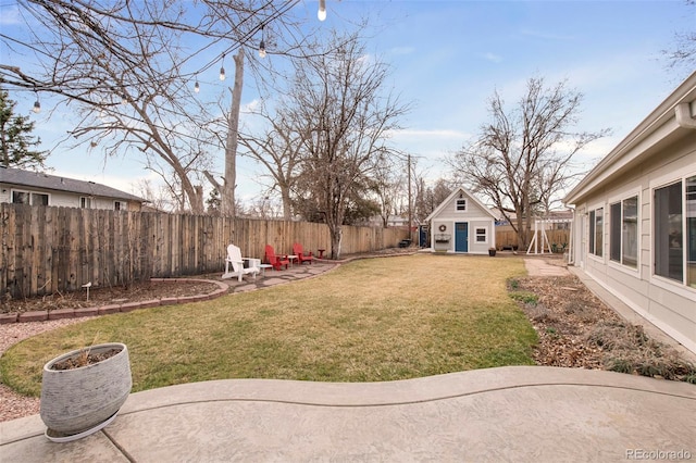 view of yard with an outdoor structure, a fenced backyard, and a patio area