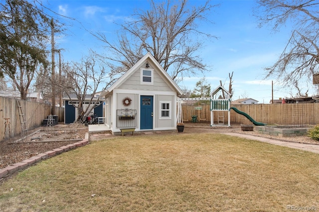 view of shed with a playground and a fenced backyard