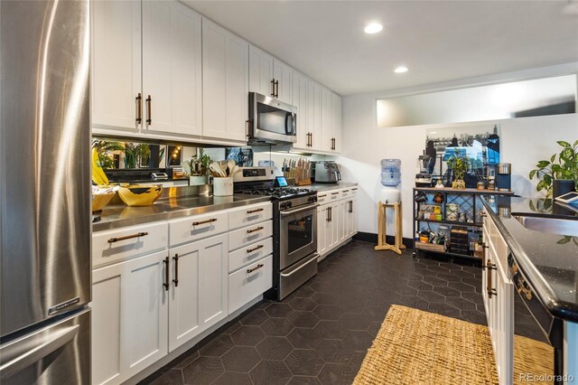 1203 24th St, Denver, CO 80205 - kitchen with stainless steel appliances, stainless steel countertops, white cabinets, recessed lighting, and dark tile patterned flooring