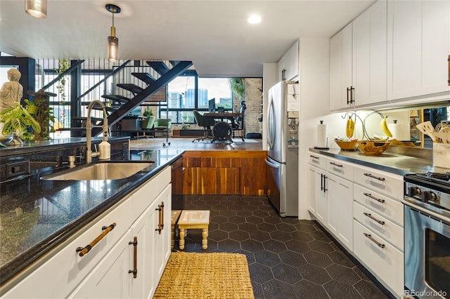 1203 24th St, Denver, CO 80205 - kitchen featuring appliances with stainless steel finishes, white cabinets, recessed lighting, hanging light fixtures, and dark stone countertops