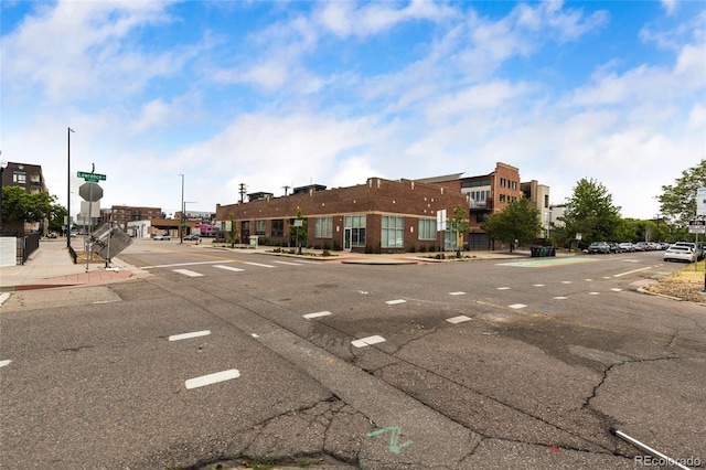 1203 24th St, Denver, CO 80205 - view of asphalt road with curbs, sidewalks, and traffic signs