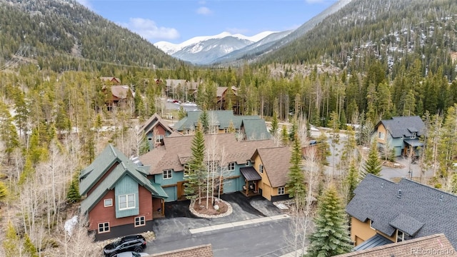 aerial view of property and surrounding area with a forest and a mountainous background