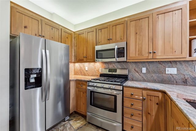 kitchen featuring stainless steel appliances, open shelves, backsplash, light stone counters, and brown cabinets