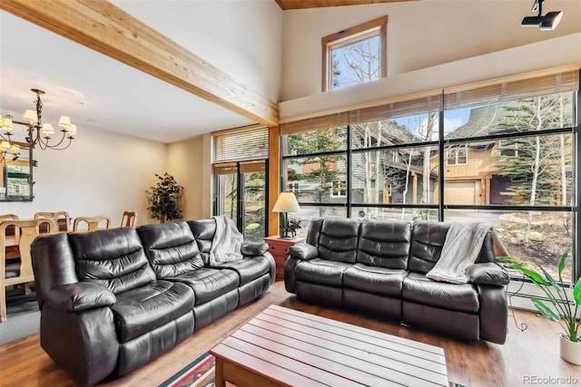 living area featuring a chandelier, wood finished floors, and a high ceiling