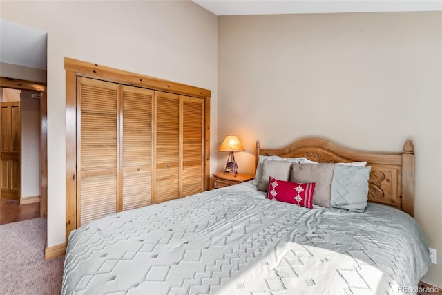 carpeted bedroom featuring baseboards and a closet