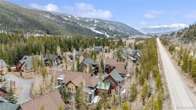 aerial view of residential area with a mountainous background and a heavily wooded area